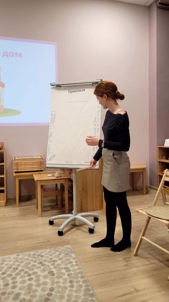Ведущая родительского клуба обсуждает доступную домашнюю среду у флипчарта