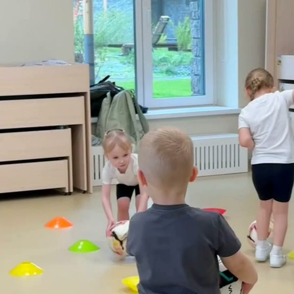 Дети с мячами и конусами на занятии по футболу в детском саду на Судостроительной
